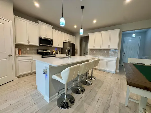 a kitchen with stainless steel appliances a stove a sink a microwave a refrigerator and cabinets