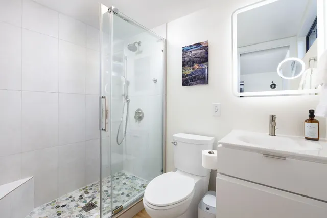 a bathroom with a sink a toilet and shower