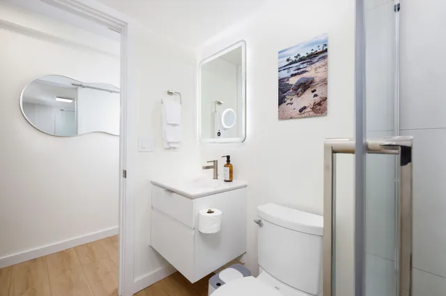 a bathroom with a toilet a sink and mirror