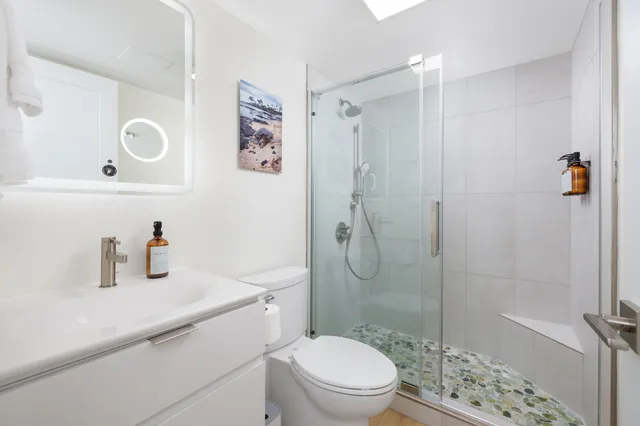 a bathroom with a sink a toilet and shower