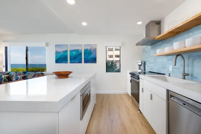 a kitchen with a sink a counter top space stainless steel appliances and a window