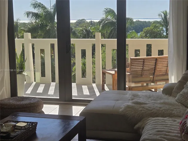 a living room with a bed furniture and a large window