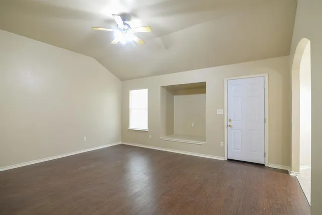 an empty room with windows and fan