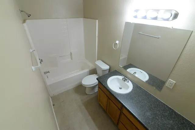 a bathroom with a double vanity sink toilet and shower