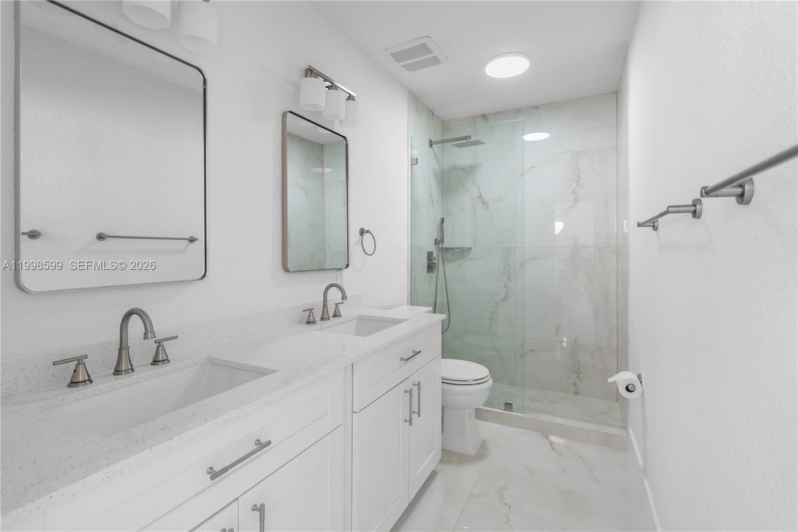 16345 Southwest 303rd Street Homestead, FL 33033 - Photo 12 of 19 a bathroom with a double vanity sink toilet mirror and shower