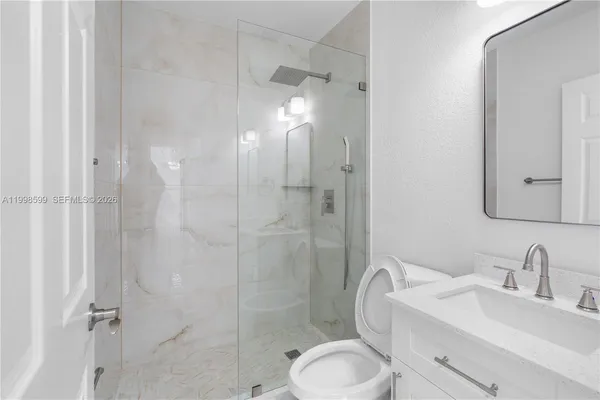 a bathroom with a granite countertop sink toilet and shower