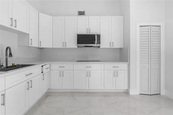 a kitchen with white cabinets and a sink