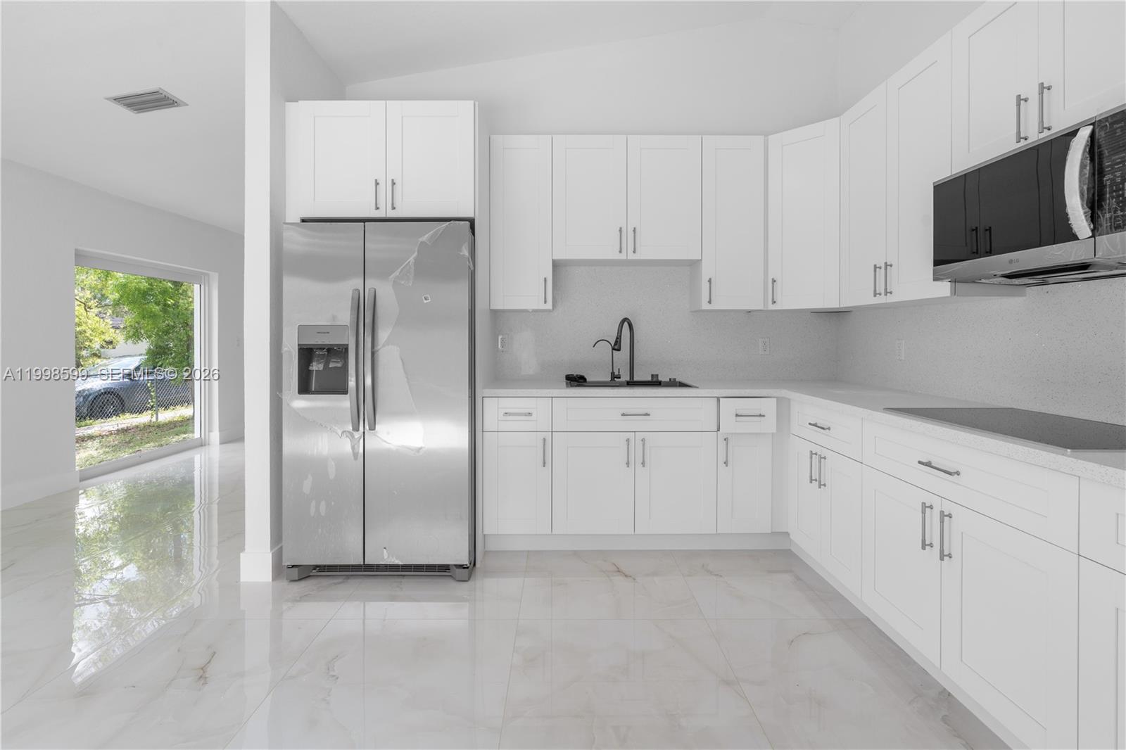 16345 Southwest 303rd Street Homestead, FL 33033 - Photo 6 of 19 a kitchen with white cabinets and refrigerator