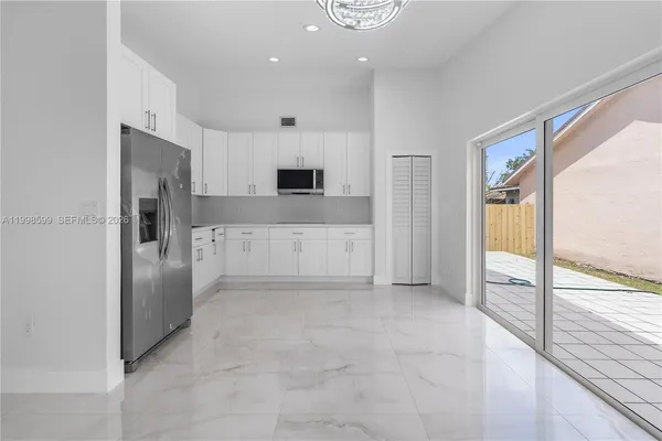 a large white kitchen with cabinets and stainless steel appliances