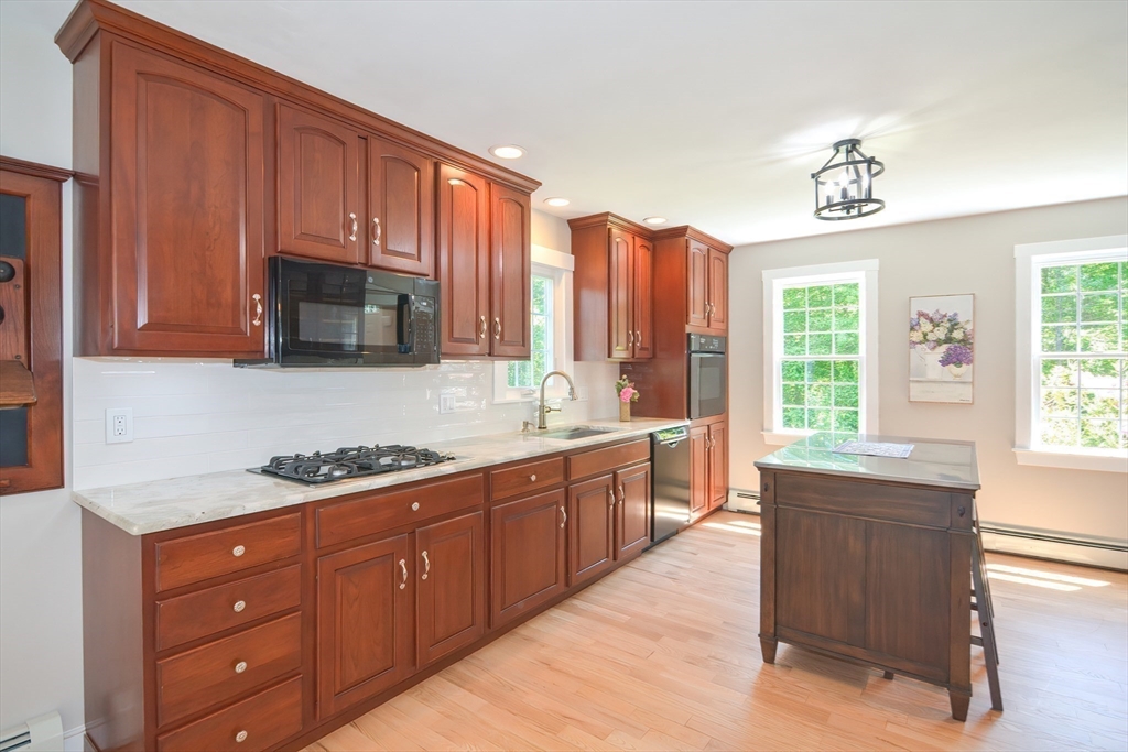 13 Park Street Mendon, MA 01756 - Photo 4 of 37 a kitchen with stainless steel appliances granite countertop a stove a sink dishwasher and a microwave oven with cabinets
