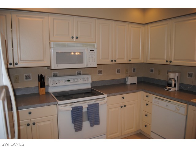 2060 Matecumbe Key Road Punta Gorda, FL 33955 - Photo 5 of 16 a kitchen with granite countertop white cabinets and white appliances