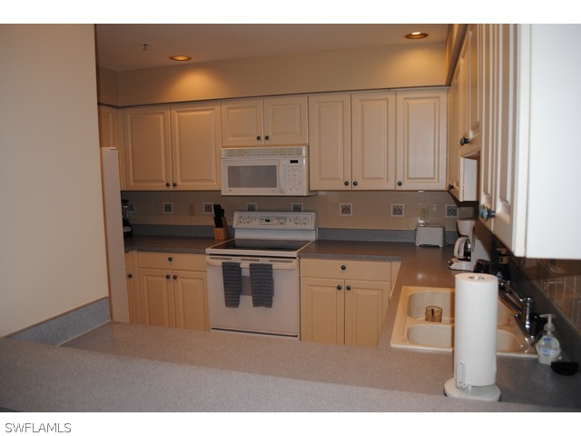 2060 Matecumbe Key Road Punta Gorda, FL 33955 - Photo 6 of 16 a kitchen with stainless steel appliances a stove a sink and white cabinets