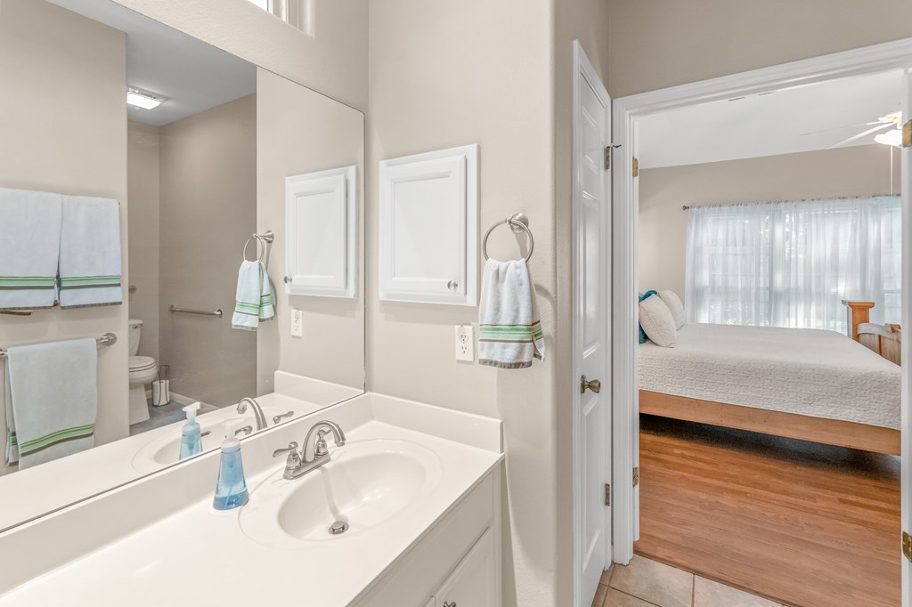 225 Los Cedros Loop Kerrville, TX 78028 - Photo 12 of 27 a en suite bathroom with a double vanity sink a mirror and shower