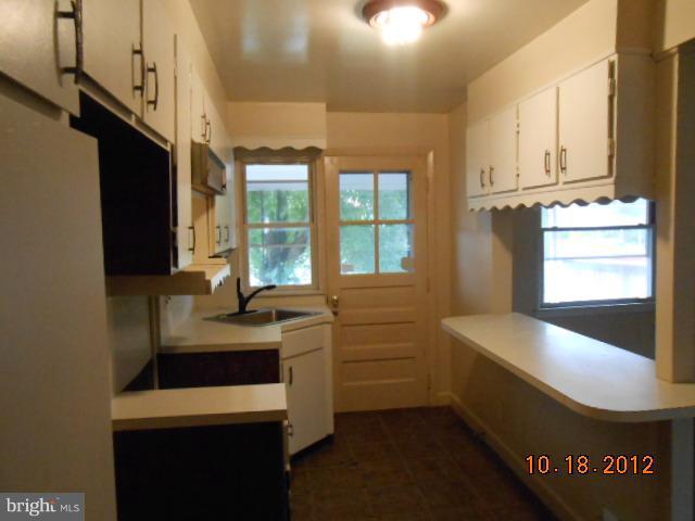 7444 Durwood Road Baltimore, MD 21222 - Photo 4 of 11 a kitchen with sink cabinets and window