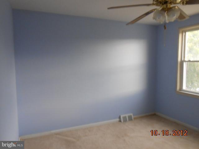 7444 Durwood Road Baltimore, MD 21222 - Photo 8 of 11 an empty room with a window and a fan