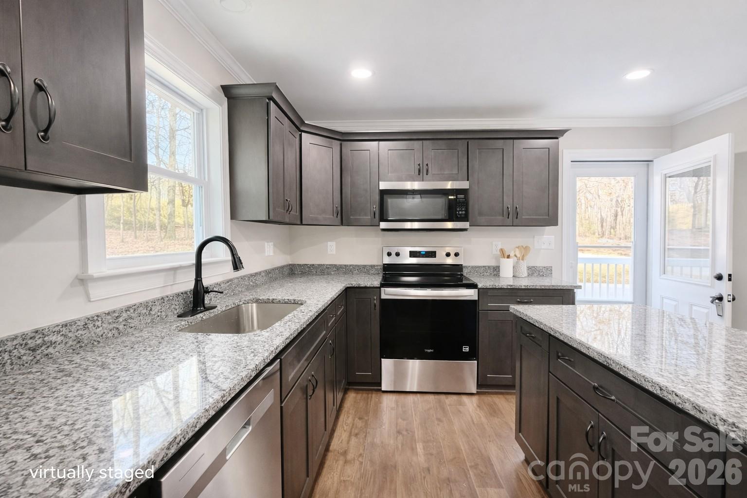 2201 Airdale Road Lancaster, SC 29720 - Photo 9 of 25 a kitchen with kitchen island granite countertop a sink appliances cabinets and a counter top space