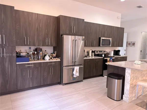 a kitchen with stainless steel appliances kitchen island granite countertop a sink and cabinets