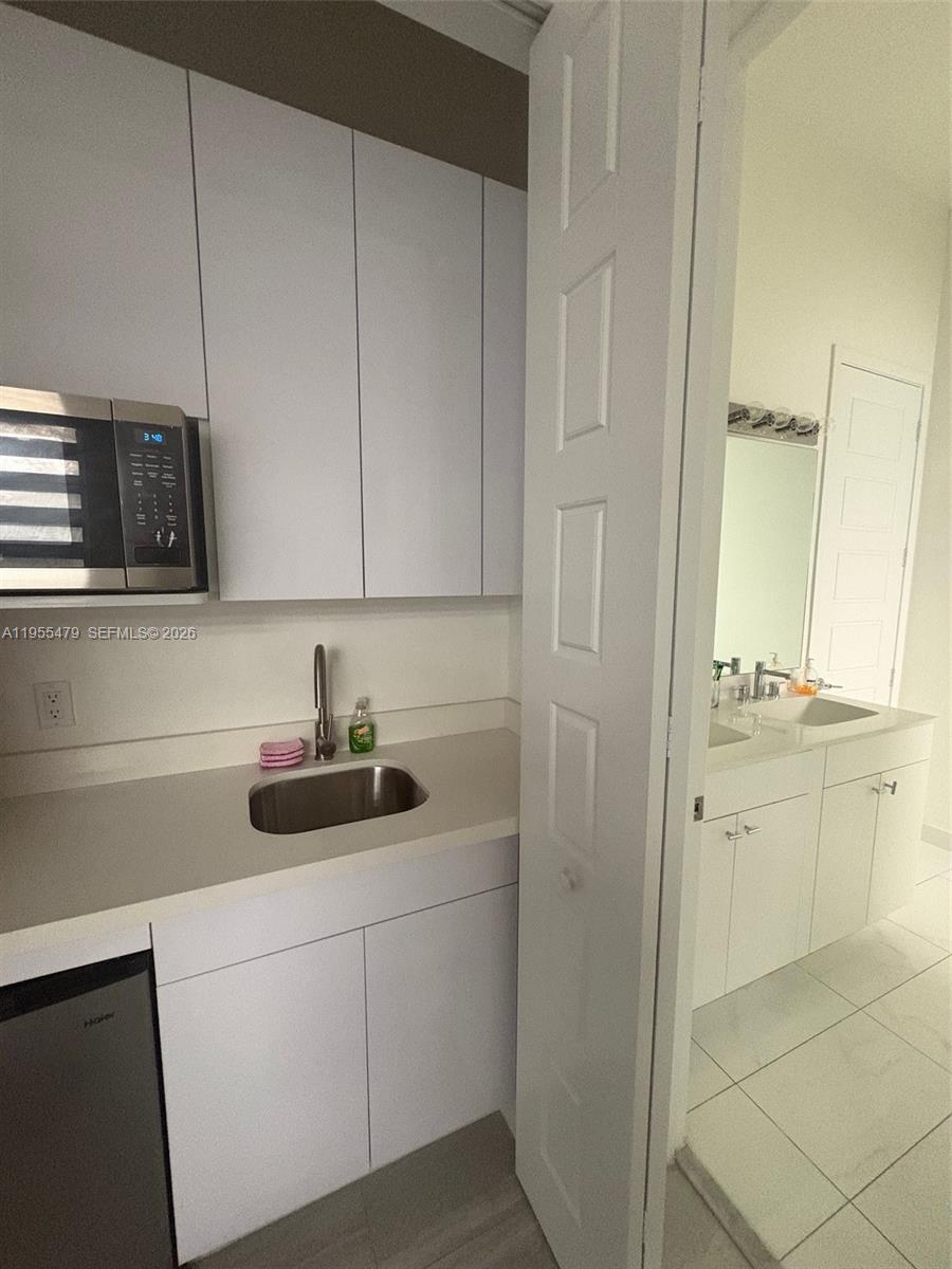 15062 Southwest 177th Terrace Miami, FL 33187 - Photo 23 of 41 a kitchen with cabinets and white appliances