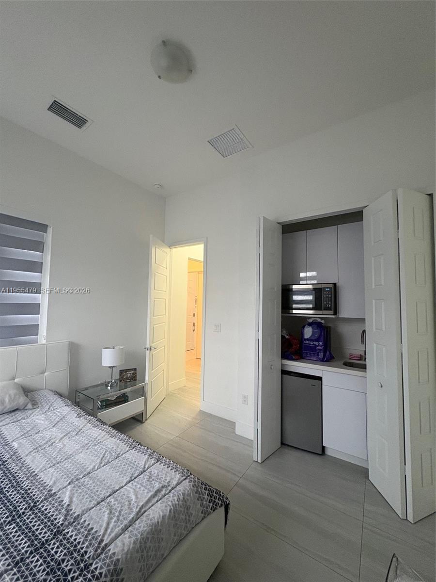 15062 Southwest 177th Terrace Miami, FL 33187 - Photo 25 of 41 a bedroom with a bed and cabinets