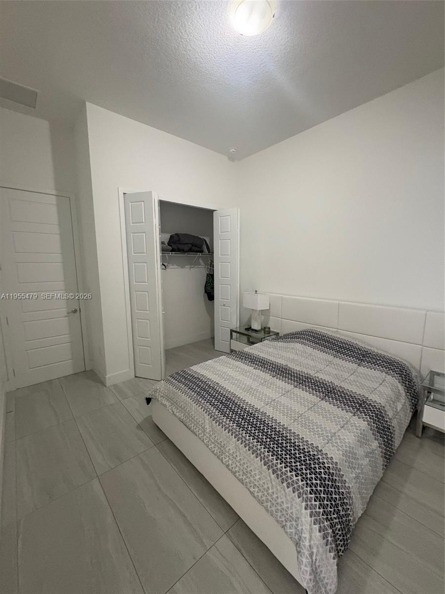 15062 Southwest 177th Terrace Miami, FL 33187 - Photo 30 of 41 a bedroom with a bed and a mirror