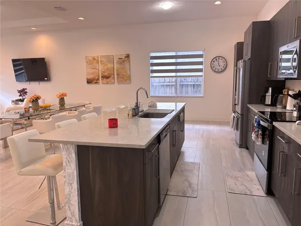 a kitchen with stainless steel appliances granite countertop a sink and a refrigerator