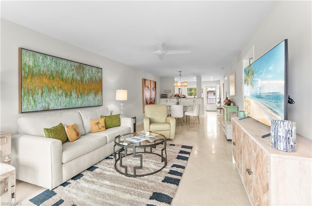 3150 Binnacle Drive, Unit 209 2J Naples, FL 34103 - Photo 12 of 32 a living room with furniture and a flat screen tv