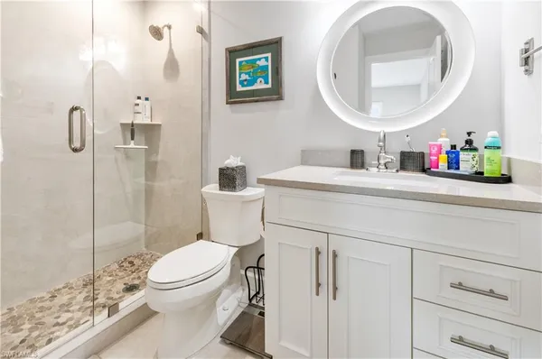 a bathroom with a toilet sink vanity and mirror