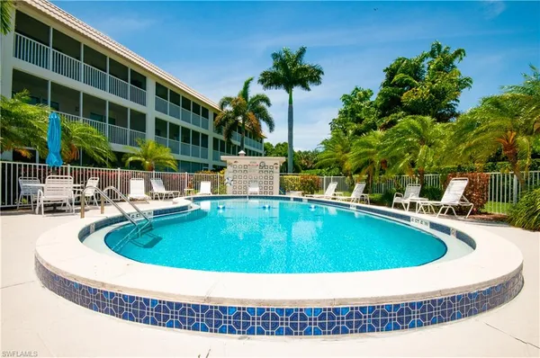 a view of swimming pool with outdoor seating and house in the background
