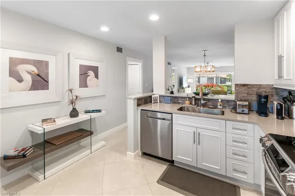 a kitchen with white cabinets and sink