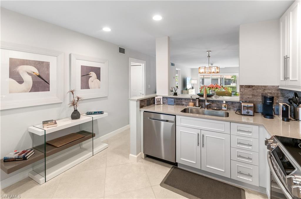 3150 Binnacle Drive, Unit 209 2J Naples, FL 34103 - Photo 3 of 32 a kitchen with white cabinets and sink