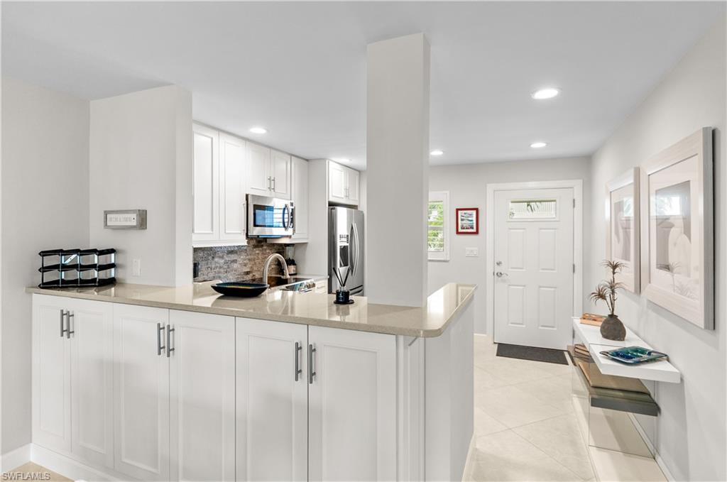 3150 Binnacle Drive, Unit 209 2J Naples, FL 34103 - Photo 4 of 32 a kitchen with granite countertop a sink and cabinets