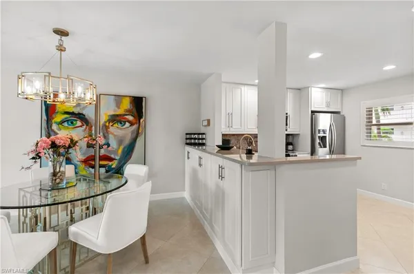 a kitchen with stainless steel appliances granite countertop a refrigerator a microwave a stove and white cabinets