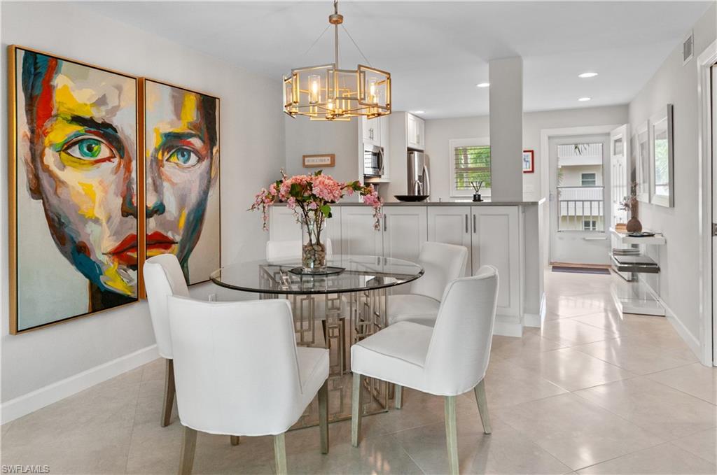 3150 Binnacle Drive, Unit 209 2J Naples, FL 34103 - Photo 7 of 32 a dining room with chandelier and wooden floor