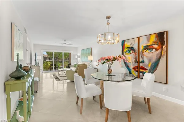 a view of a dining room with furniture a livingroom and chandelier