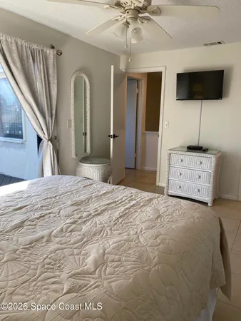 a bedroom with a bed a flat screen tv and dresser
