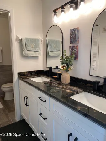 a granite counter top a sink a mirror and a window
