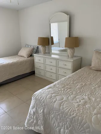a bedroom with a bed and a lamp on dresser