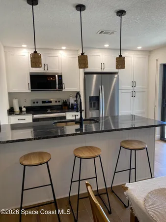 a kitchen with stainless steel appliances granite countertop a sink a stove a microwave a counter space and cabinets