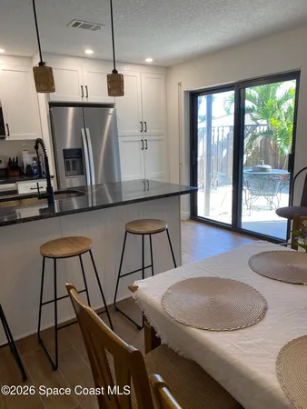 a kitchen with a table chairs and a wooden floor
