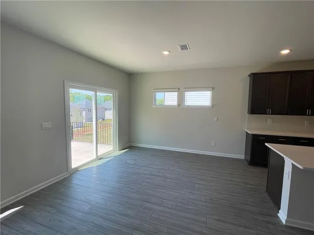 an empty room with wooden floor and a cabinet
