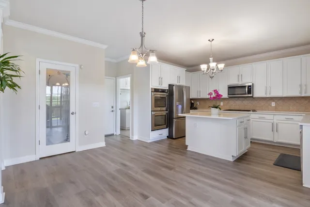 a kitchen with stainless steel appliances kitchen island a refrigerator and a stove top oven