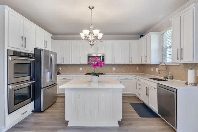 a kitchen with stainless steel appliances granite countertop a sink dishwasher a refrigerator and a stove