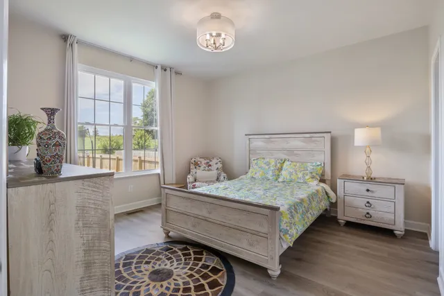 a bedroom with a bed and a lamp on dresser