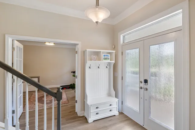 a view of a hallway with wooden floor and staircase