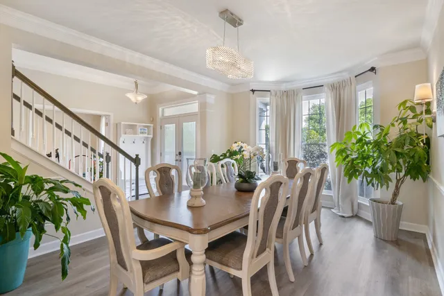 a dining room with furniture potted plants and wooden floor