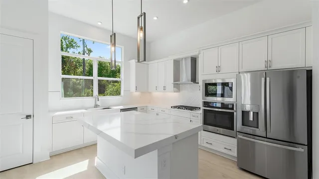 a kitchen with stainless steel appliances a refrigerator sink and microwave