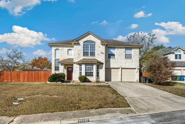 a front view of a house with a yard and trees
