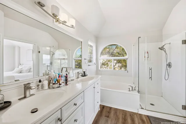 a bathroom with a tub sink a mirror and a shower