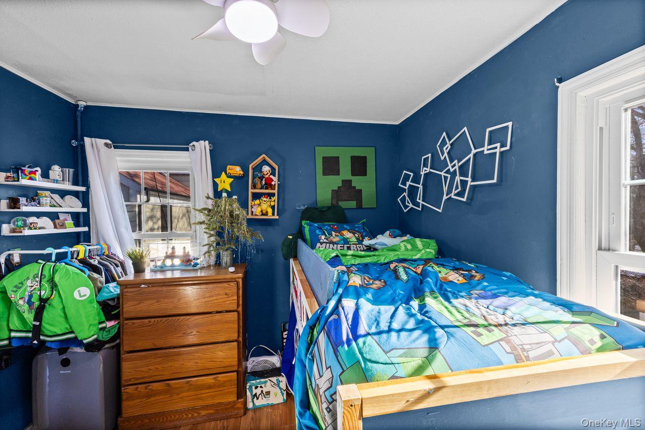 50 Poseidon Road Rocky Point, NY 11778 - Photo 16 of 47 a bedroom with a bed and a chandelier