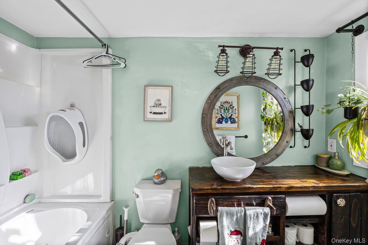 50 Poseidon Road Rocky Point, NY 11778 - Photo 18 of 47 a bathroom with a toilet a sink and a mirror